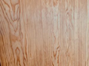 Surface en bois clair avec un grain marqué et des motifs ondulés. Planches de pin naturel pour revêtement de sol ou mural.