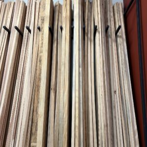 Présentoir de liteaux bruts en bois de diverses dimensions (ex: 8x27mm, 27x50mm) avec étiquettes de prix de 0€68 à 3€11 TTC.